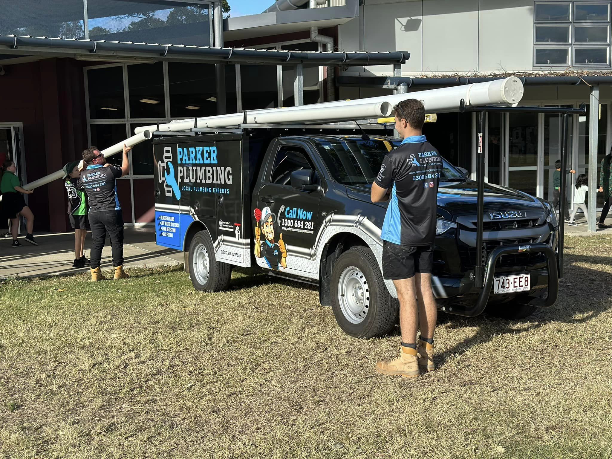 Parker Plumbing employee taking pipes off the roof of the work car
