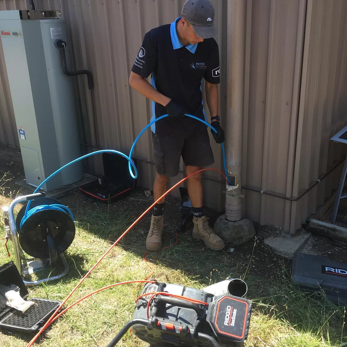 plumber holding a cable which is in a pipe to inspect a blockage