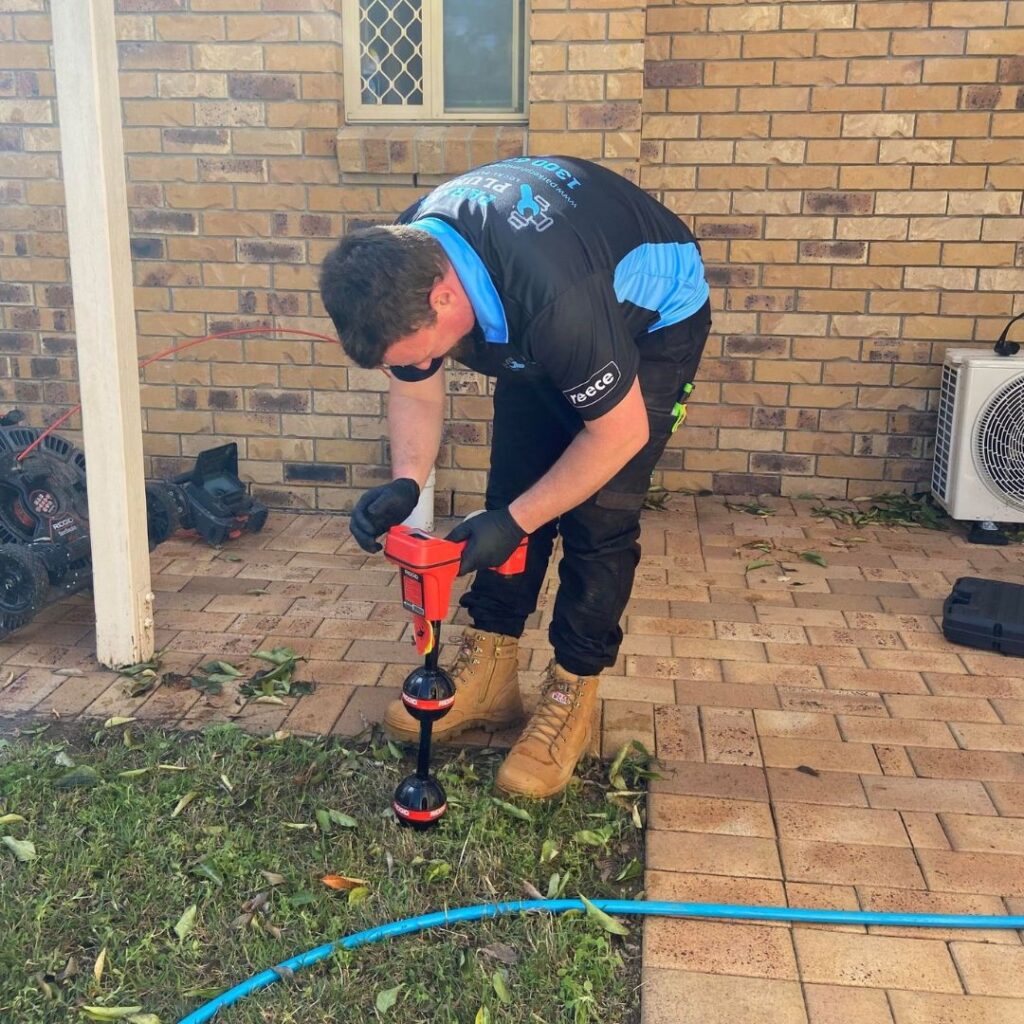 man using a device to detect pipes underground